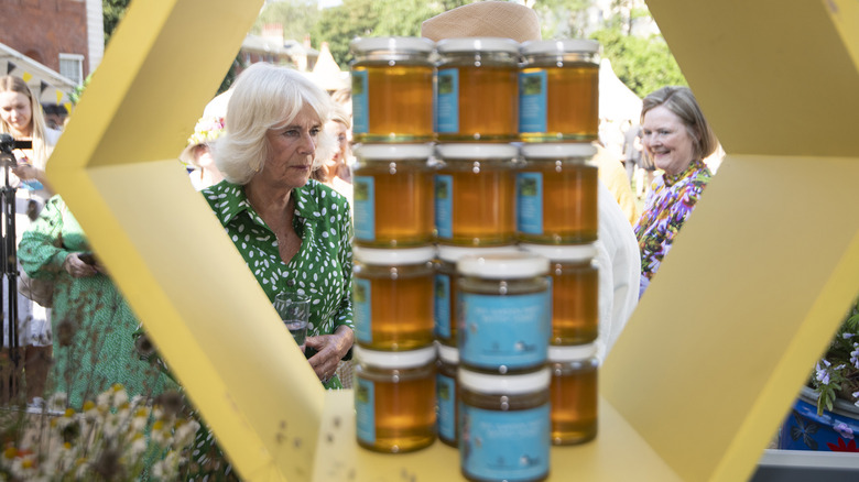 Camilla, Queen Consort standing in front of honey 