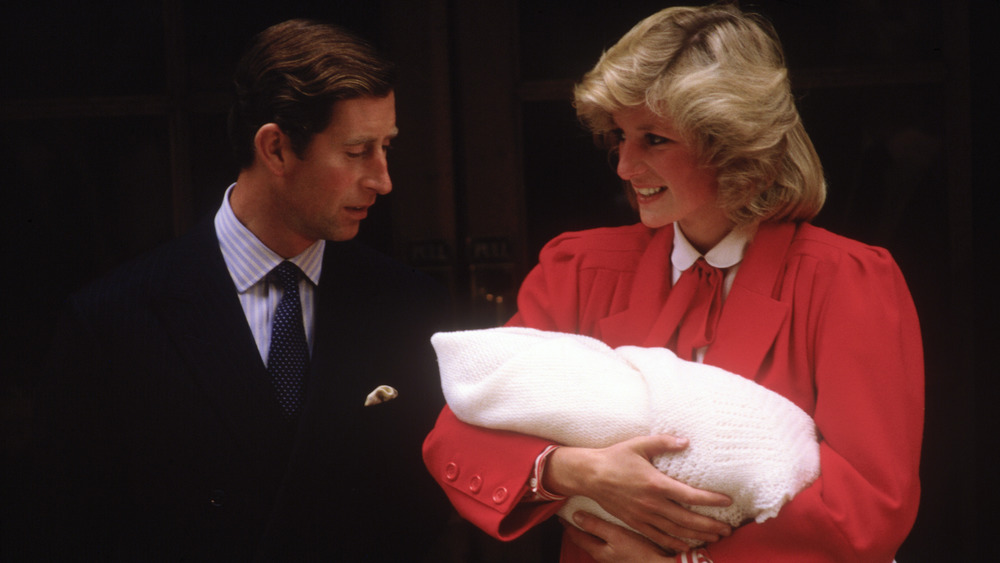 Princess Diana cradling Prince Harry with Prince Charles