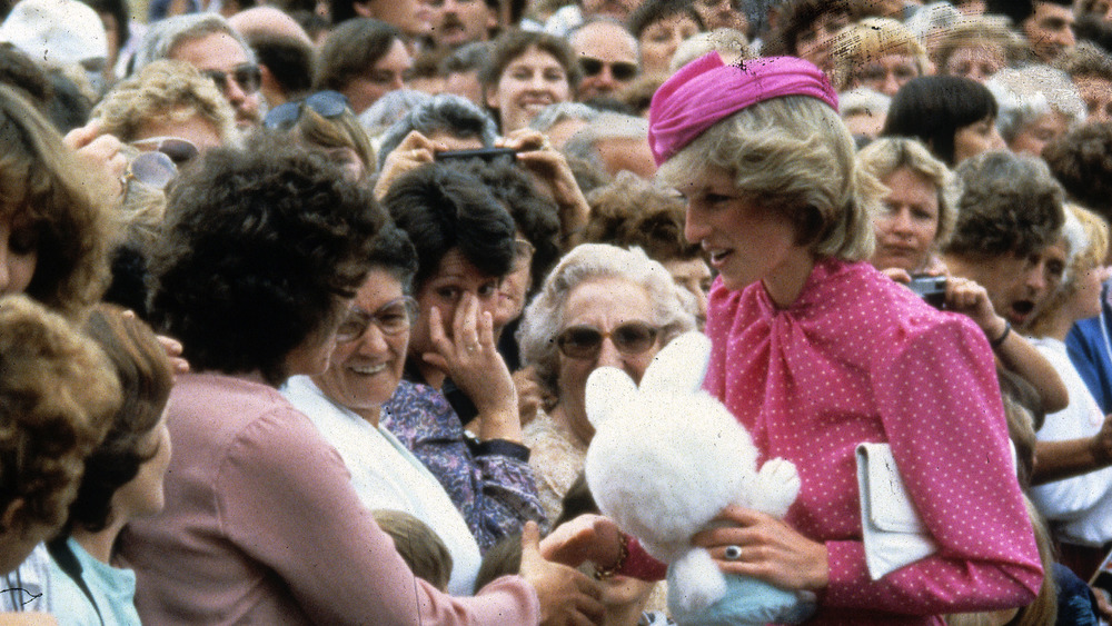 Princess Diana in a crowd holding a stuffed animal