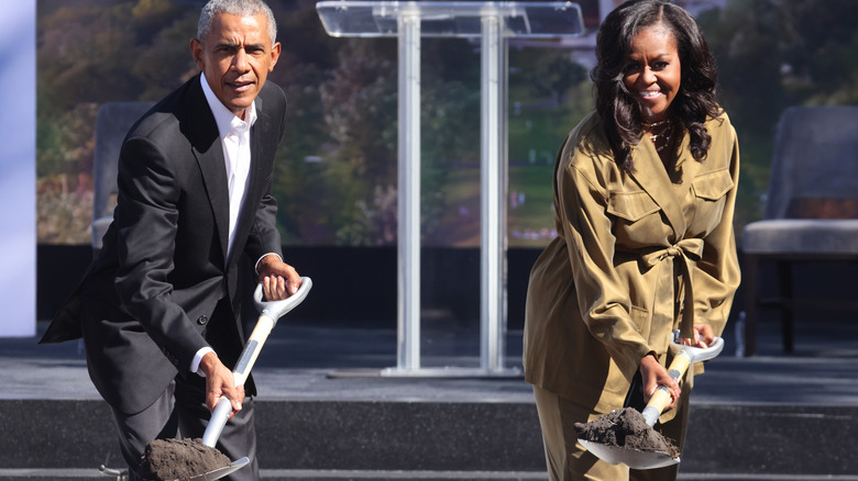 Michelle Obama and Barack Obama holding shovels