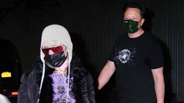 Grimes and Elon Musk wearing medical masks