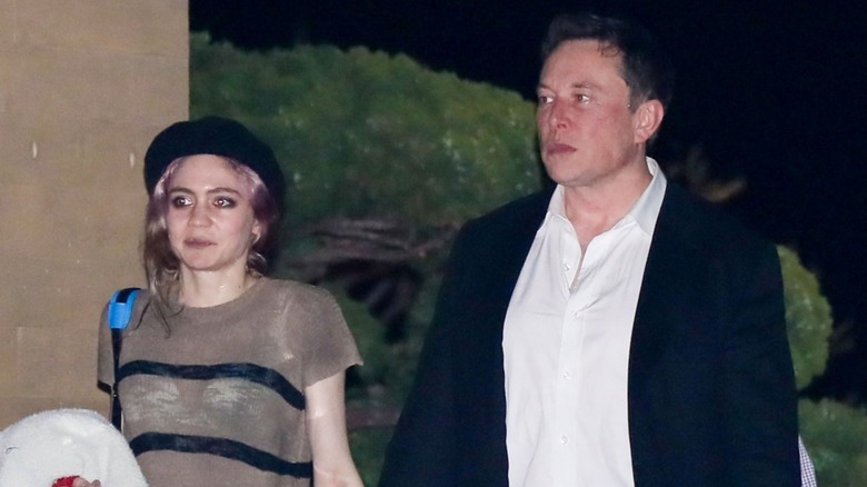 Elon Musk and Grimes with serious faces