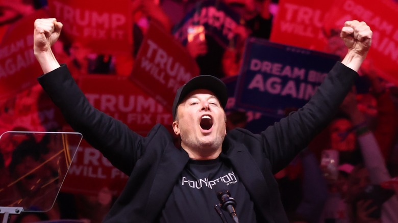 Elon Musk raising his arms at a Trump rally