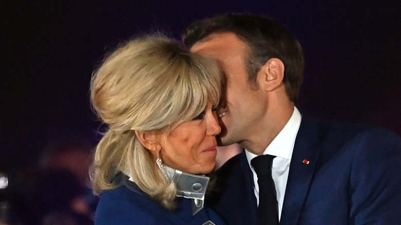 Macrons embracing, Emmanuel kissing Brigitte's cheek