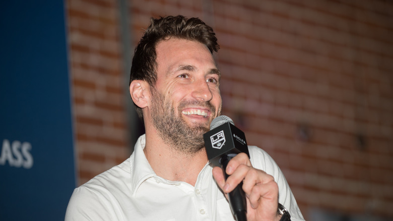 jarret stoll smiling while holding a microphone