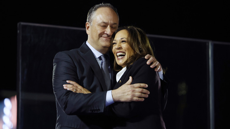 Kamala Harris, smiling, is embraced by second gentleman Doug Emhoff