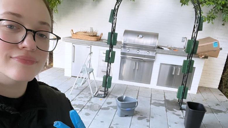 Kat Dennings posing in front of wedding arch project