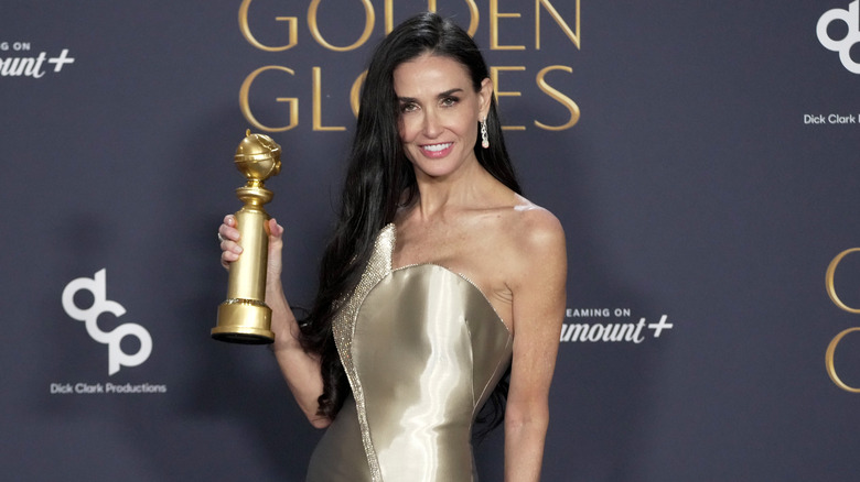 Demi Moore posing with her Golden Globe award