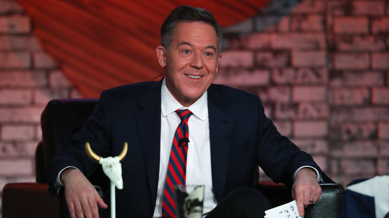 Greg Gutfeld wears a striped tie while sitting