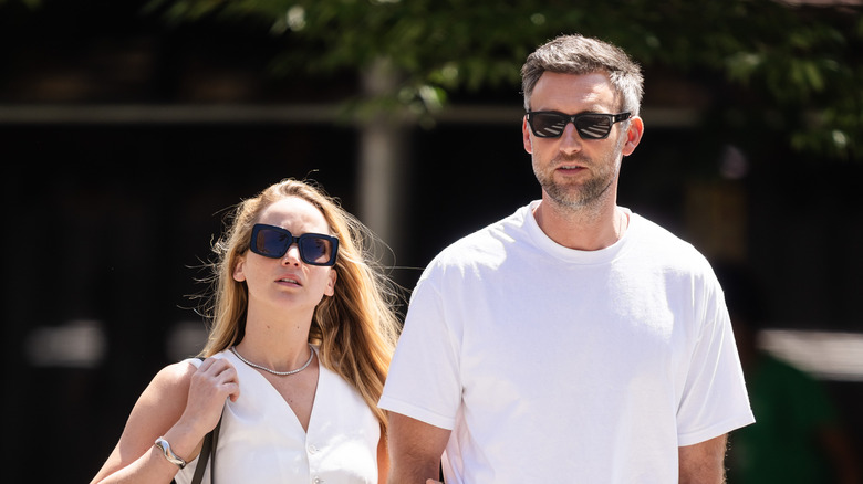 Jennifer Lawrence and Cooke Maroney walking while wearing sunglasses.