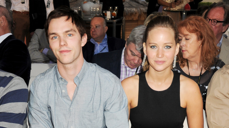 Jennifer Lawrence and Nicolas Hoult smiling together at the camera.