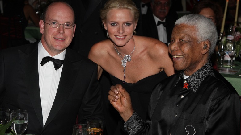 Prince Albert, Princess Charlene, and Nelson Mandela smiling