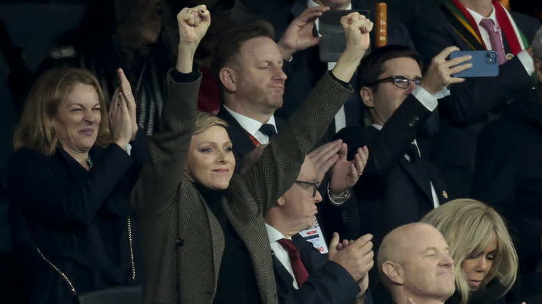 Princess Charlene with arms raised at game 