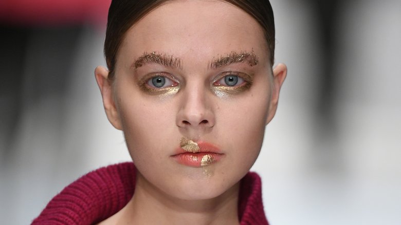 Runway model sporting glitter brows, eyes, and lips