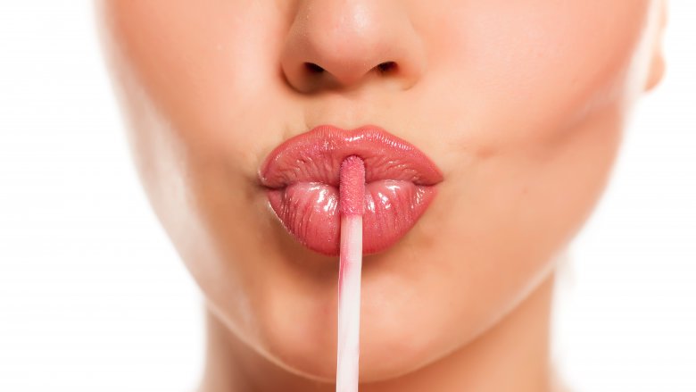 woman applying lip gloss