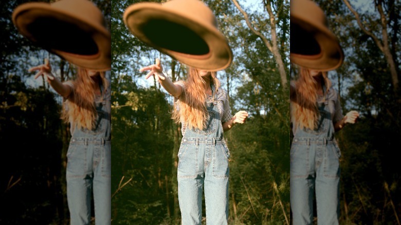 Blonde woman throwing cowboy hat