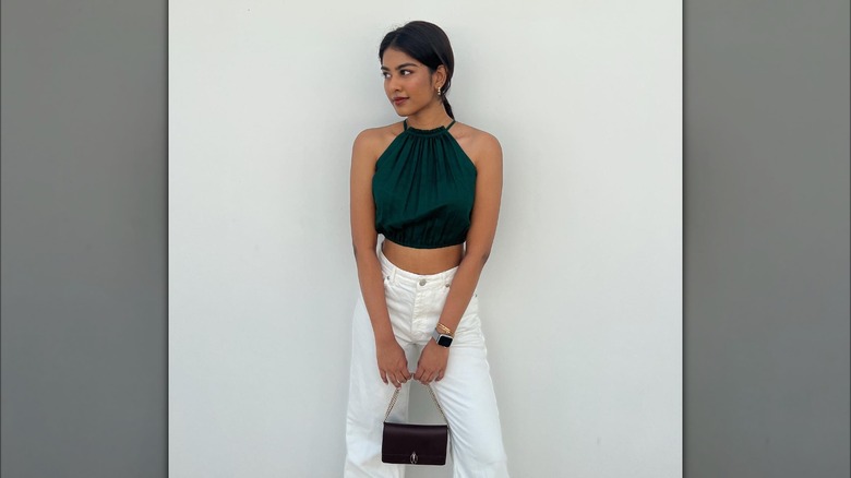 @divyaboppana_ posing in green halter top and white pants