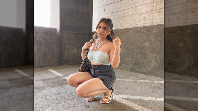 @ootd.diana squatting in black shorts and halter top