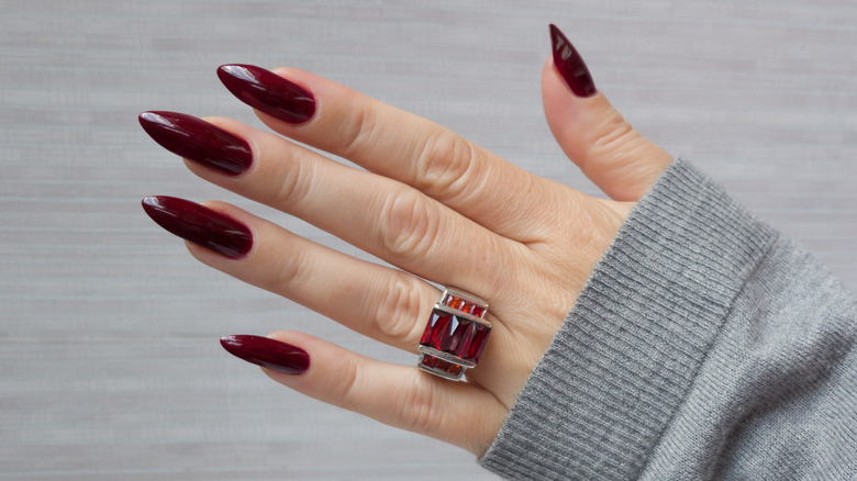 Woman's hand with wine-colored nails