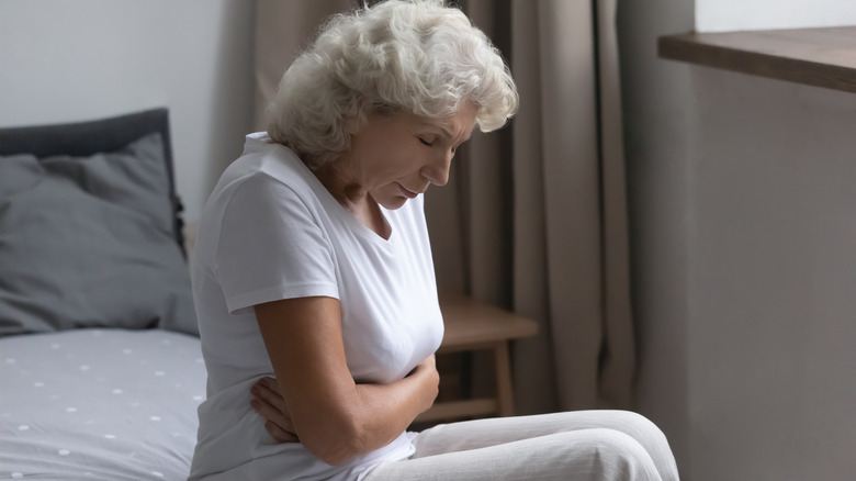 Older woman holding stomach