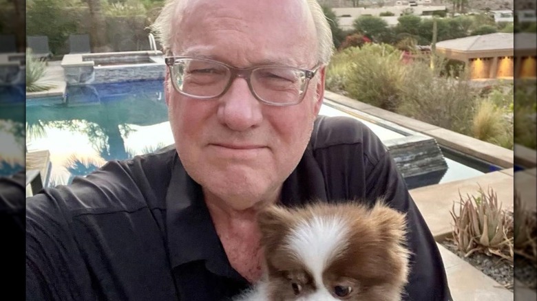 Bill Geddie holding dog by pool