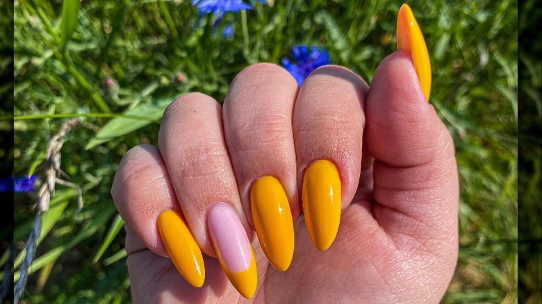 hand with yellow nail art 