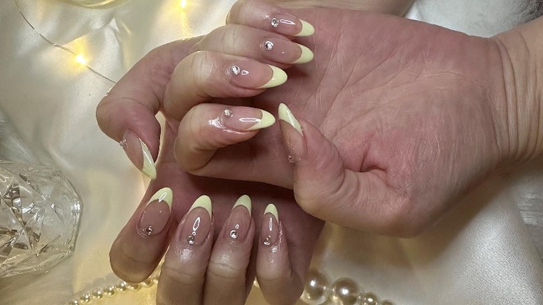 Yellow modern french manicure with gemstones