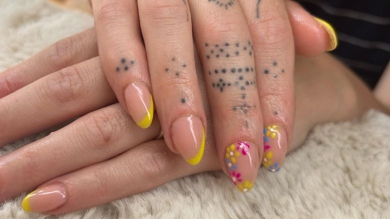 Hands with yellow floral nail art