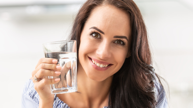 Person holding glass of water