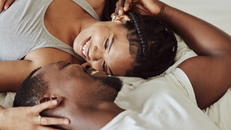 Couple smiling and touching in bed