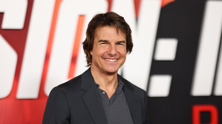 Tom Cruise smiling in a dark jacket