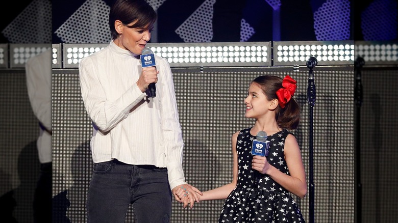 Katie Holmes with Suri Cruise talking on stage with mics