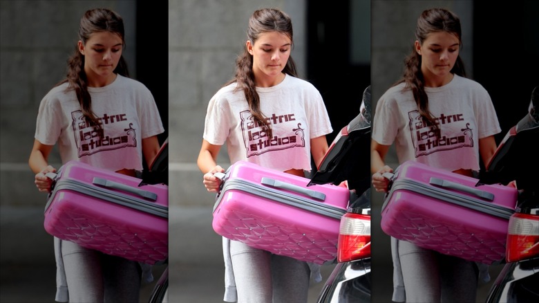 Suri Cruise carrying suitcase