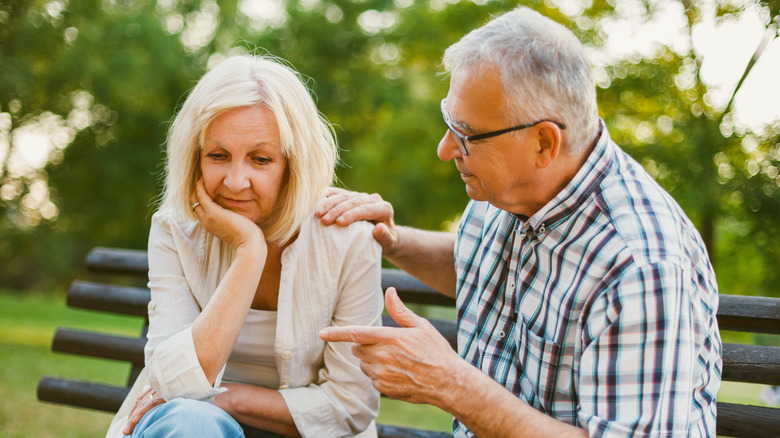 woman sitting on bench with man