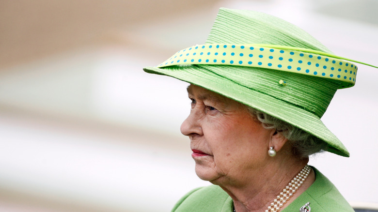 Quen Elizabeth II somber in green hat