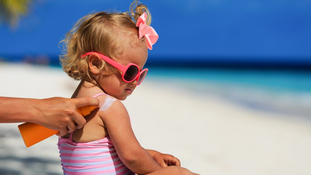 Mother applying sunscreen on baby