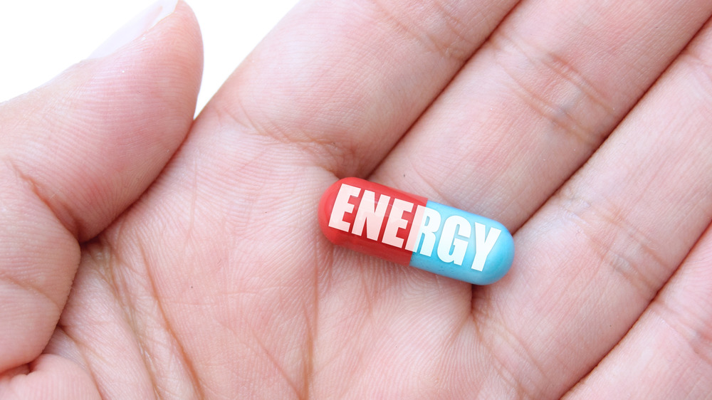Woman holding energy pill