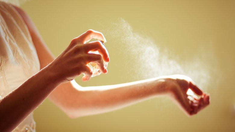 woman spraying perfume