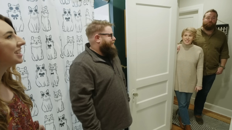 HGTV contestants and cast standing in bathroom 