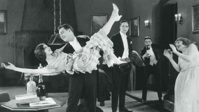 A man and woman dancing in front of a small crowd in 1920s