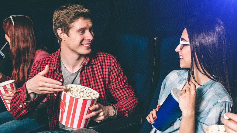 man sharing popcorn with woman