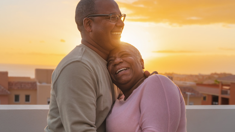 older Black couple hugging each other