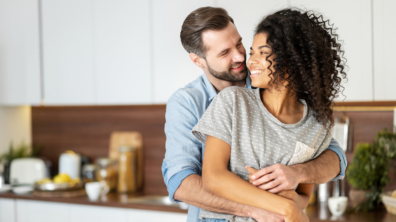 Interracial couple embracing in the kitchen