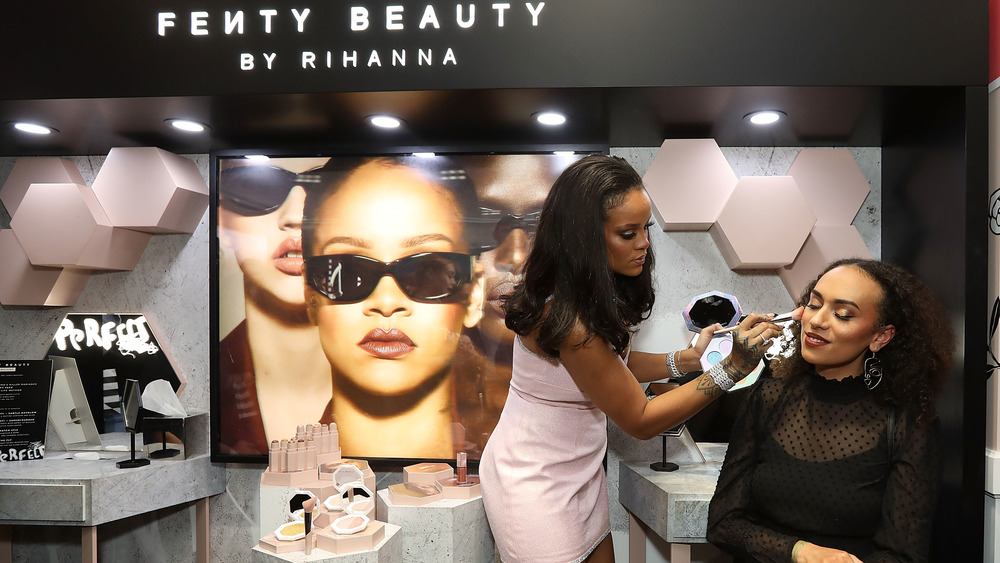 Rihanna applying makeup Fenty Beauty