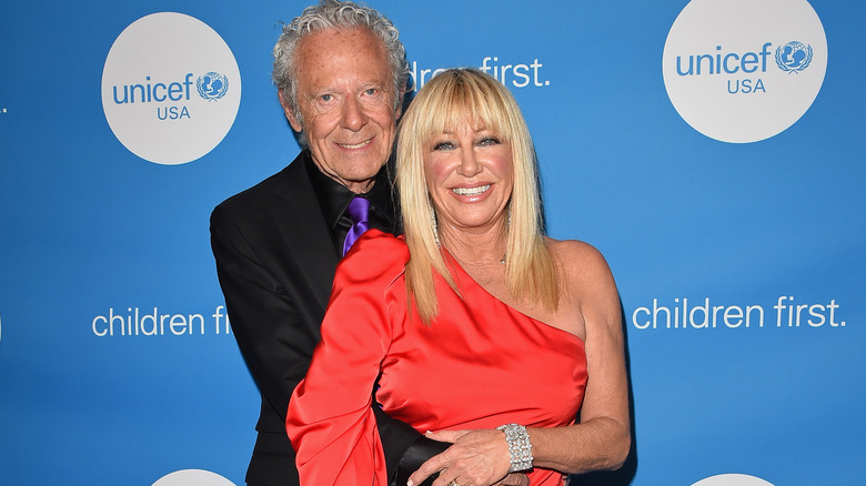 Alan Hamel and Suzanne Somers smiling and holding hands