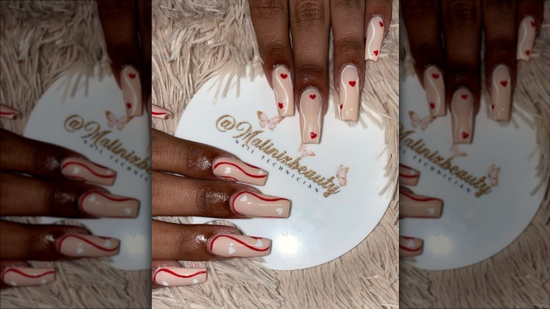 Pink nails with red swirls and hearts