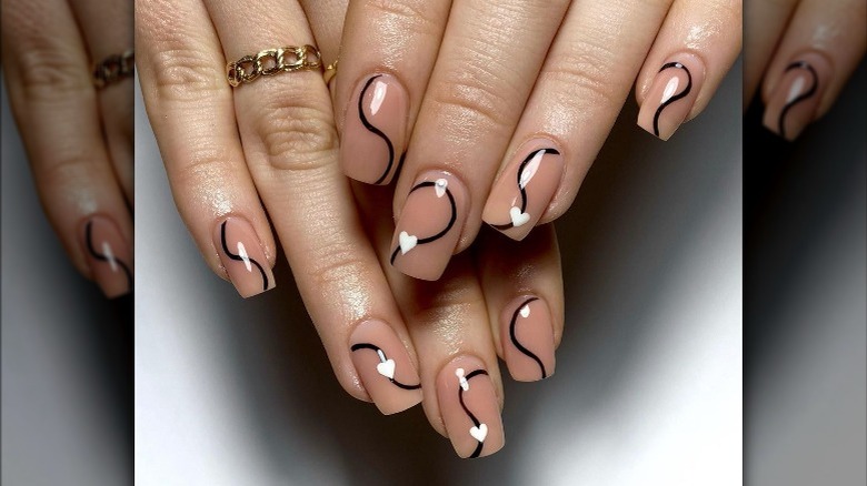 Nude, white, and black swirl nails