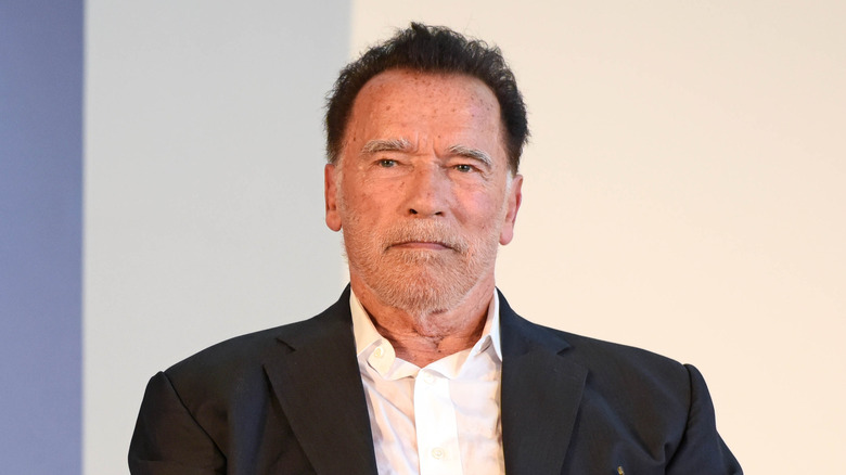 Arnold Schwarzenegger sitting looking serious