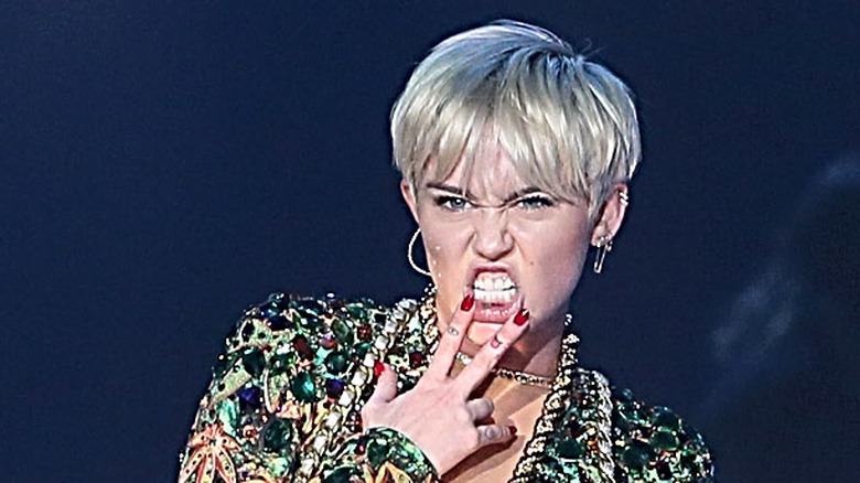 Miley Cyrus showing lip tattoo