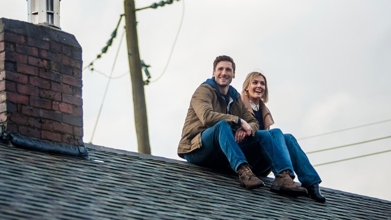 Andrew Walker and Taylor Cole sitting on a roof in Appetite for Love